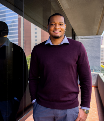 man standing next to the JFK school of Law building 