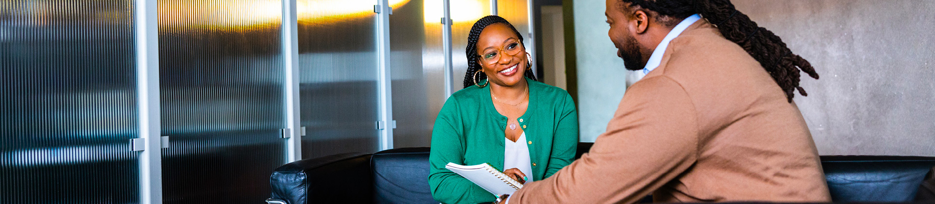 Brittneii P. talks to a colleague in a conference room