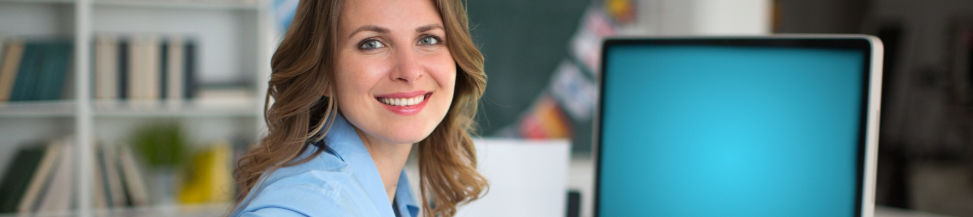 Person looking at camera in front of computer monitor