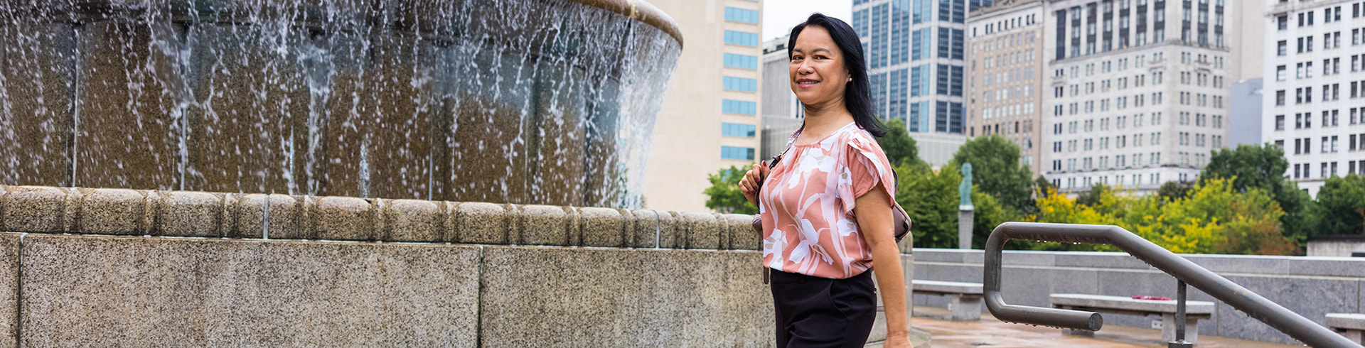 Woman walking downtown by big fountain