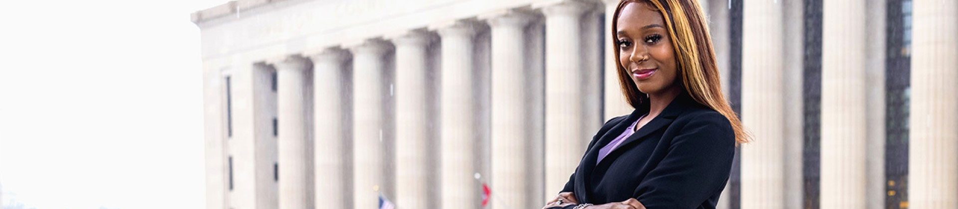 Doctor of Criminal Justice graduate posing in front of courthouse