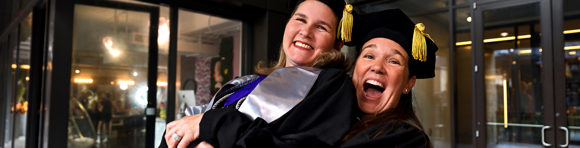 Couple excited and holding each other at graduation