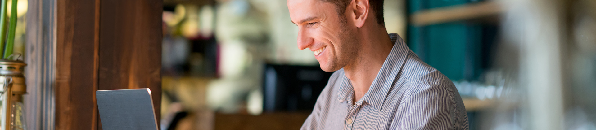 man smiling down at laptop