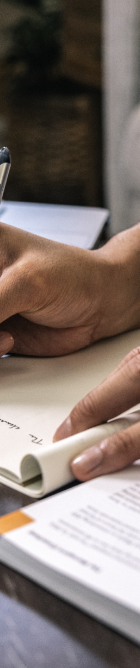 closeup of hands of a person taking notes for a class