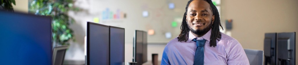 man stands next to a computer