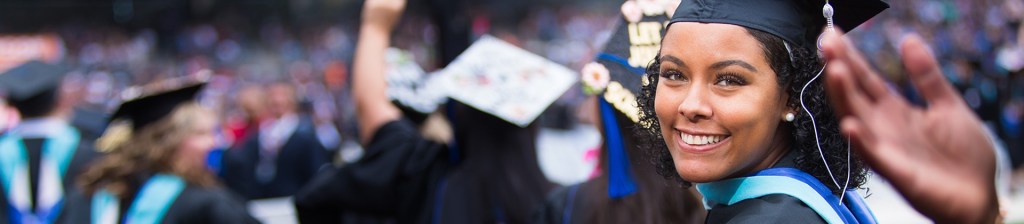 woman in a crowd of graduates looks back at the camera