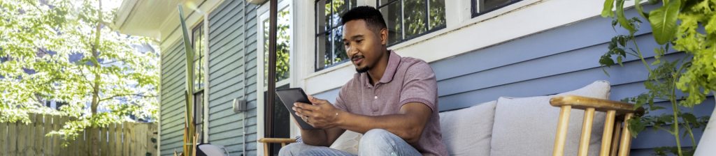 man works on a tablet on his porch