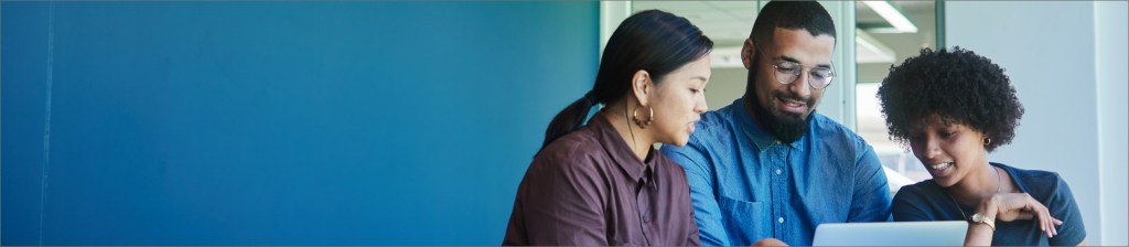three people looking at a laptop together