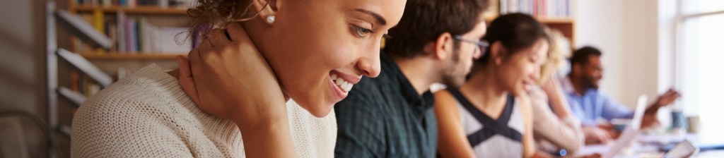 five students in classroom, sitting at long table